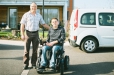 Portrait d'un père et son fils en fauteuil roulant dans un véhicule Citiz adapté "PMR".